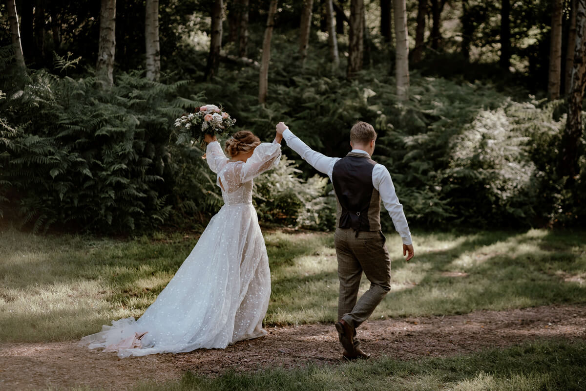Bride and groom celebrating in at an outdoor eco-friendly wedding. Willow and Rust eco-friendly wedding stylist