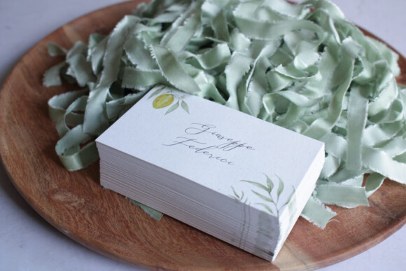 Common wedding stationery mistakes how to avoid them. Wedding guest names. Place cards piled with vegan bamboo silk ribbon, pale sage.