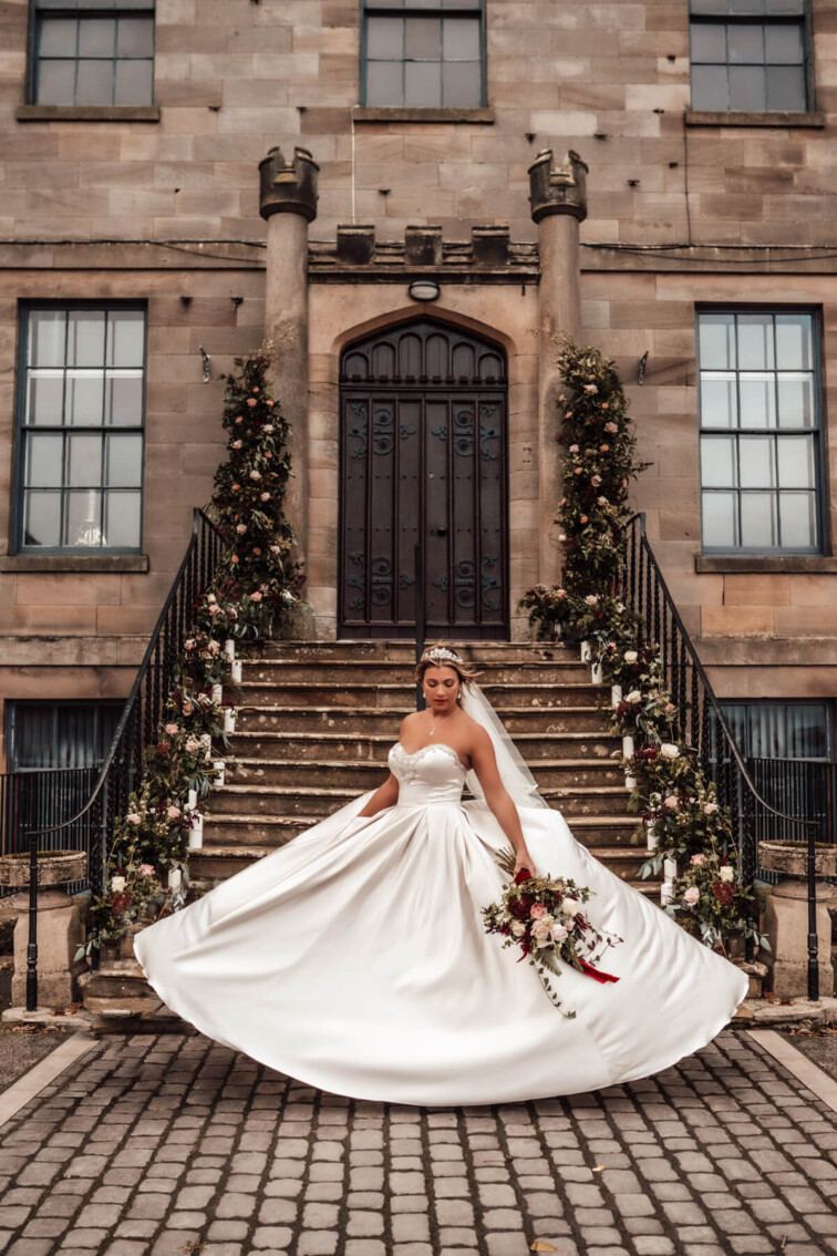 Bride twirling in front of Sneaton Castle. Winter wedding inspiration.