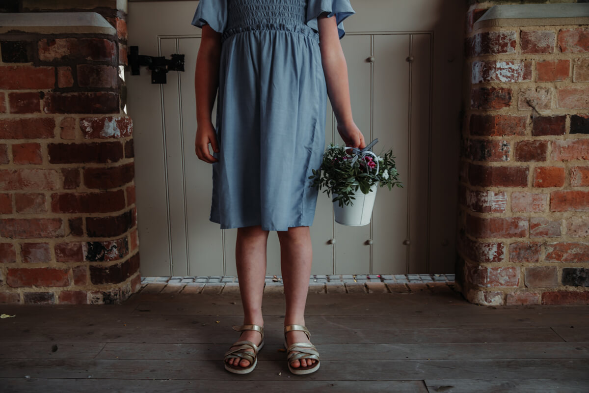 Flower girl holding flower bucket. Children at wedding.