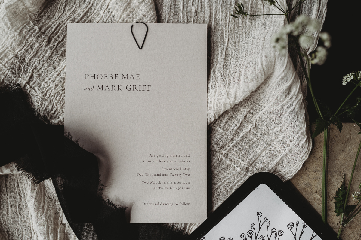 Stone and black minimal wedding invitation with gypsophila detail. Monotone stationery