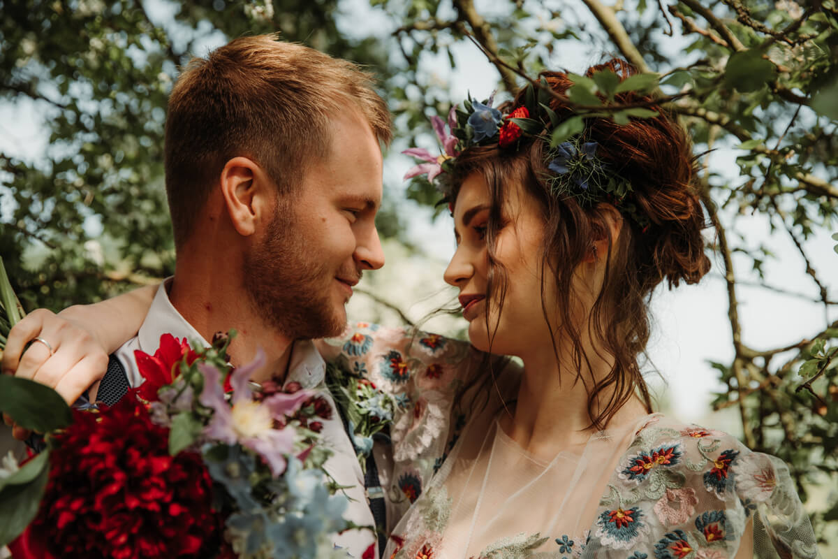 Gothis summer wedding with deep plum florals and green foliage. Bride floral head crown