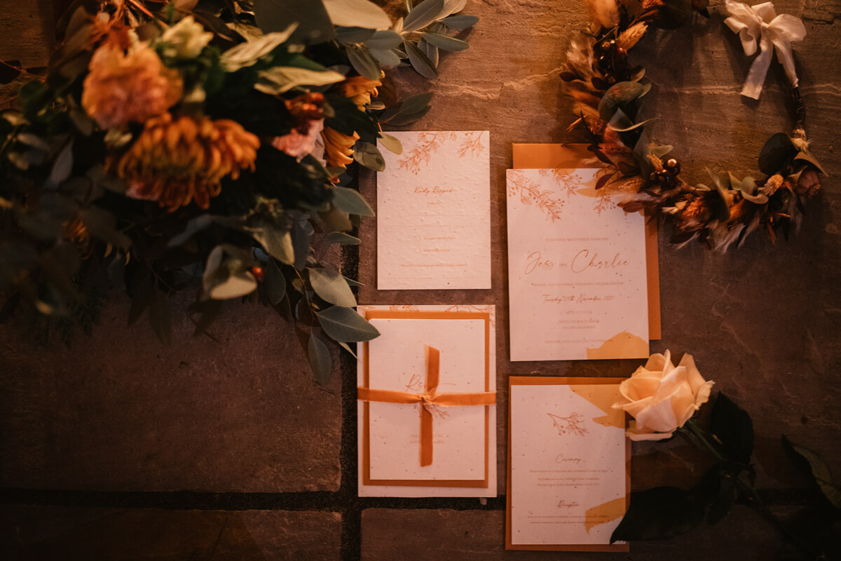 Plantable seeded wedding invitation set with burnt orange envelope and ribbon. Autumn wedding.