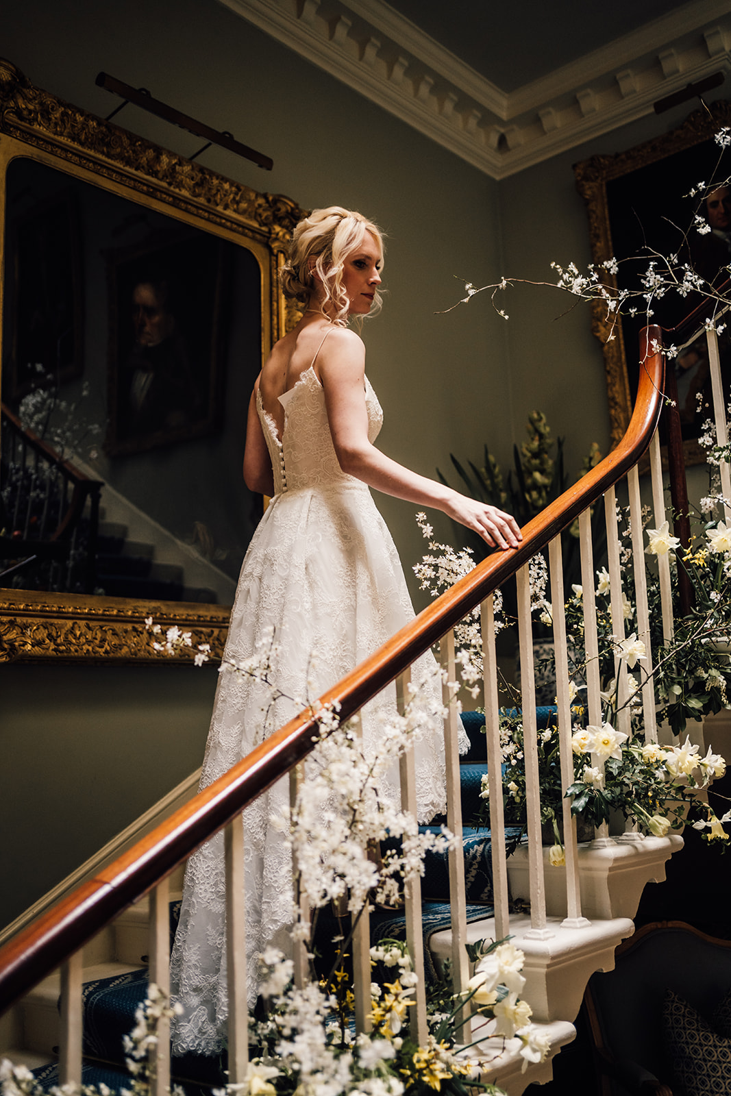 Bride walking up staircase at Norwood park with Spring flowers